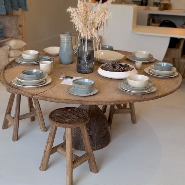 Table ronde en bois dressée avec de la vaisselle en céramique au showroom Masamé