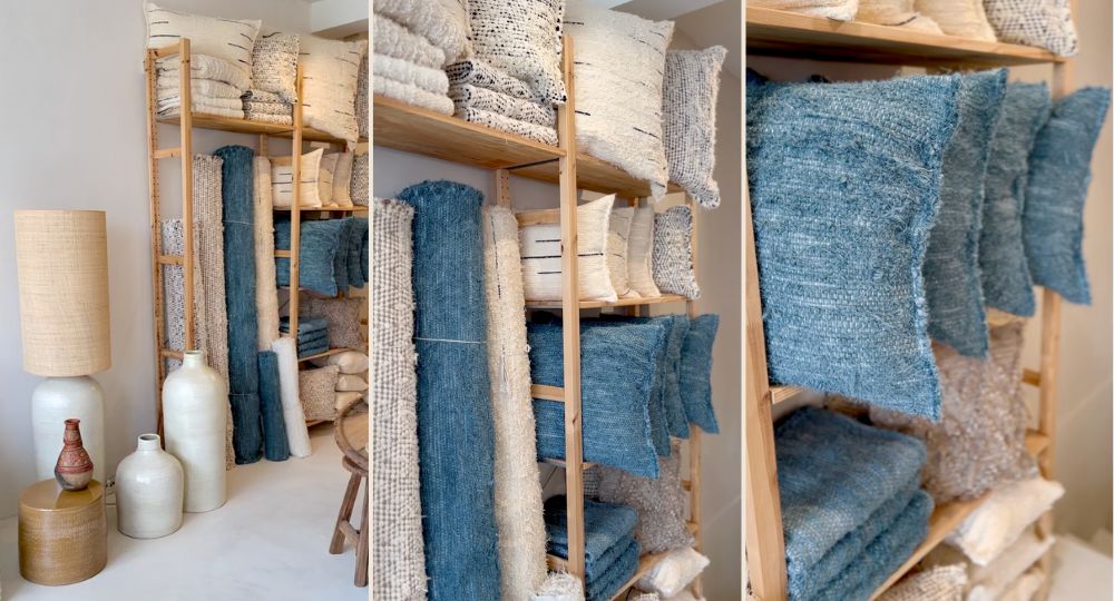 Étagères du showroom Masamé avec tapis et coussins en laine bleus et écrus